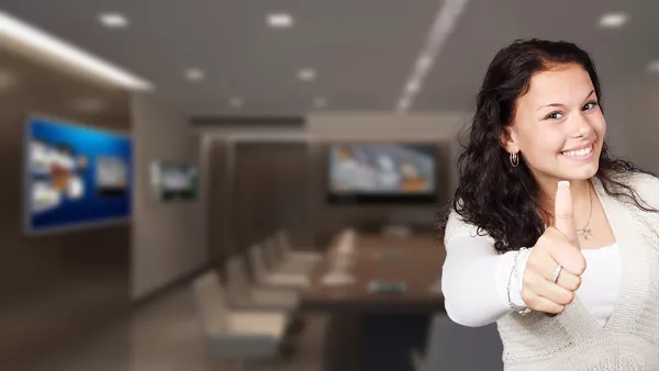 A lady with brown hair and a big smile is giving the &apos;thumbs-up&apos; to the camera.