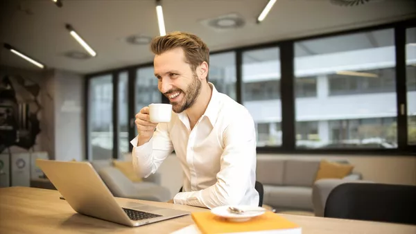 A man enjoys a cup of coffee whilst attending a pivot & scale workshop.